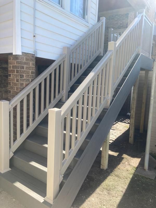A set of stairs leading up to a house with a white railing