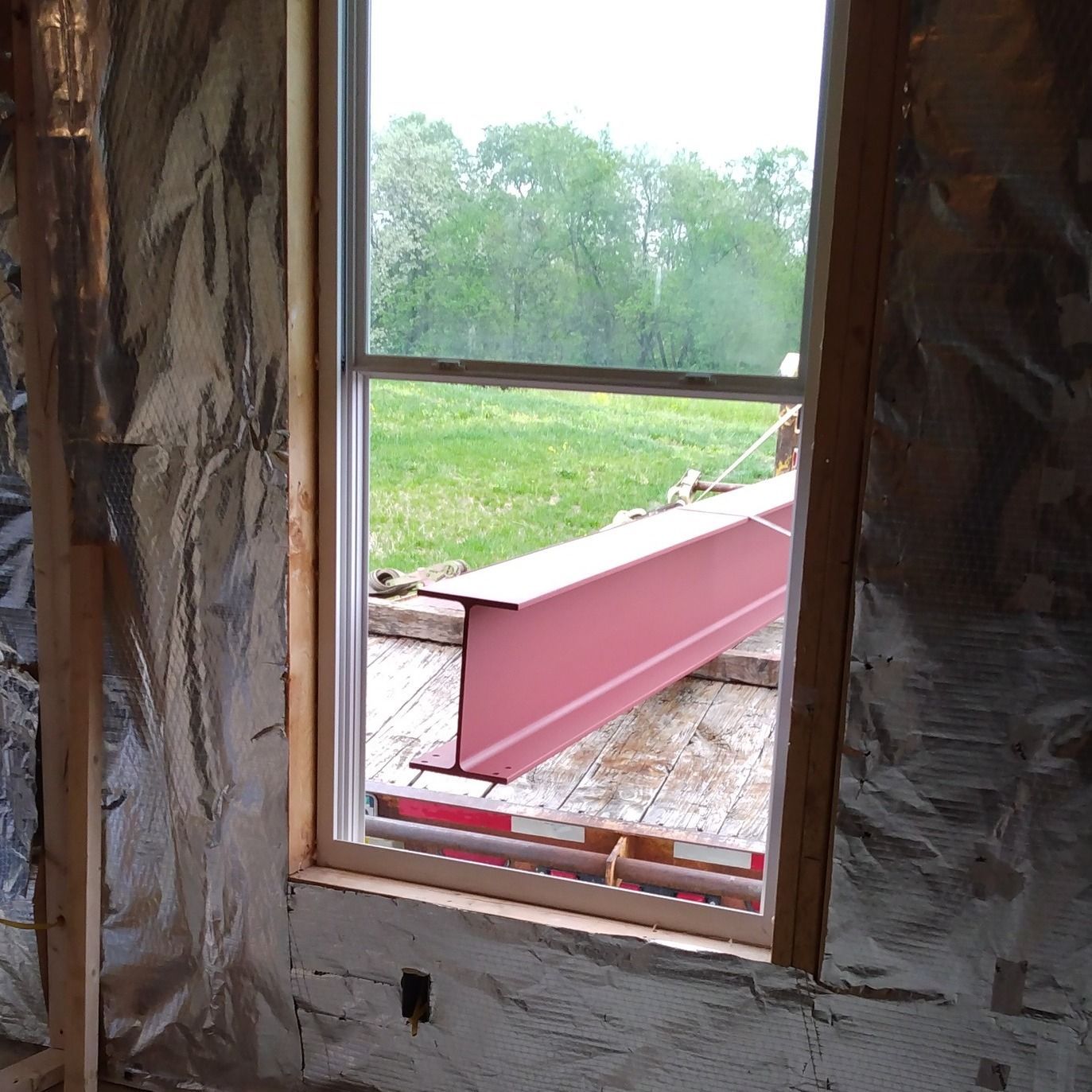 A window with a pink beam hanging out of it