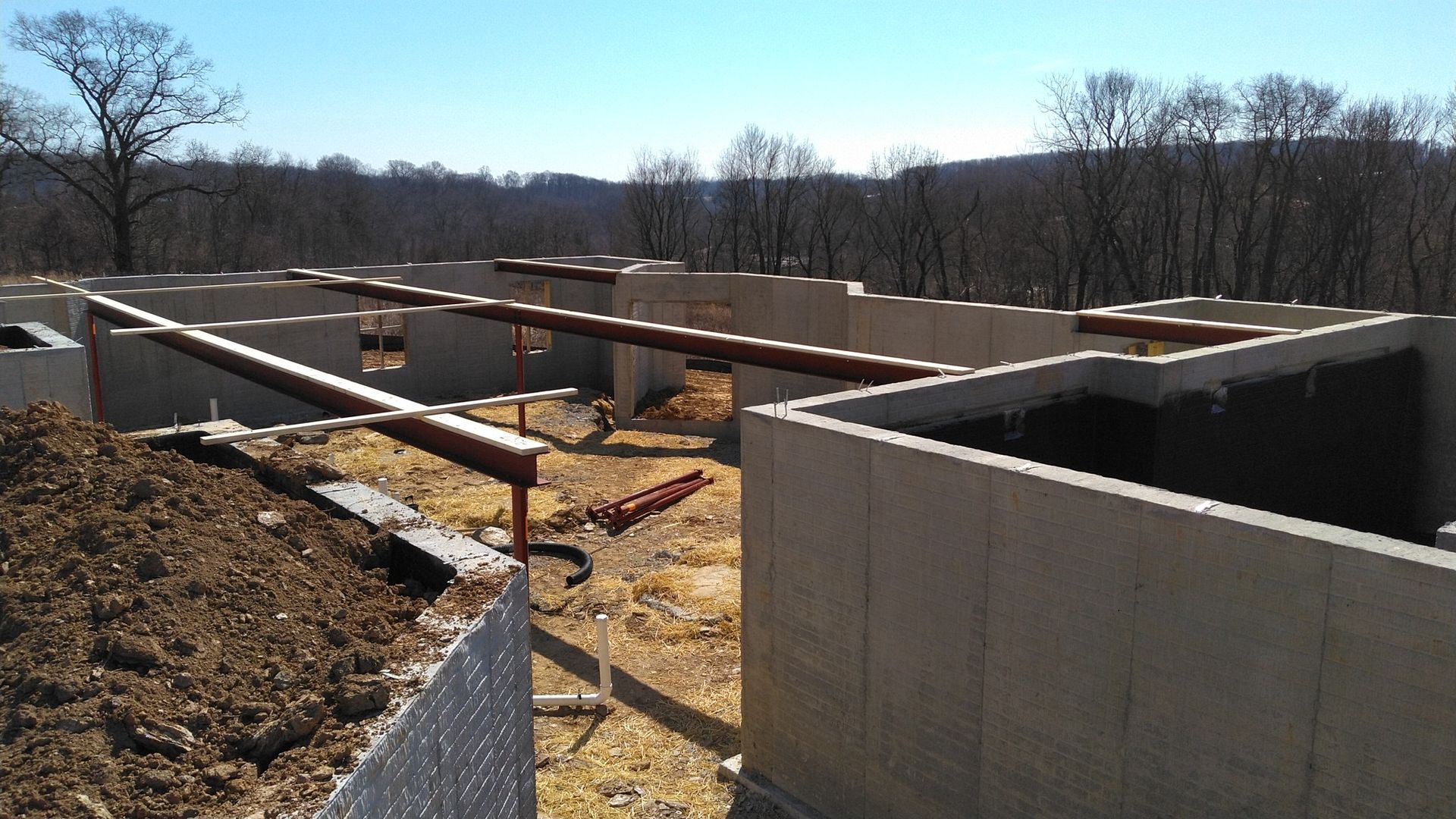 A construction site with a lot of dirt and trees in the background