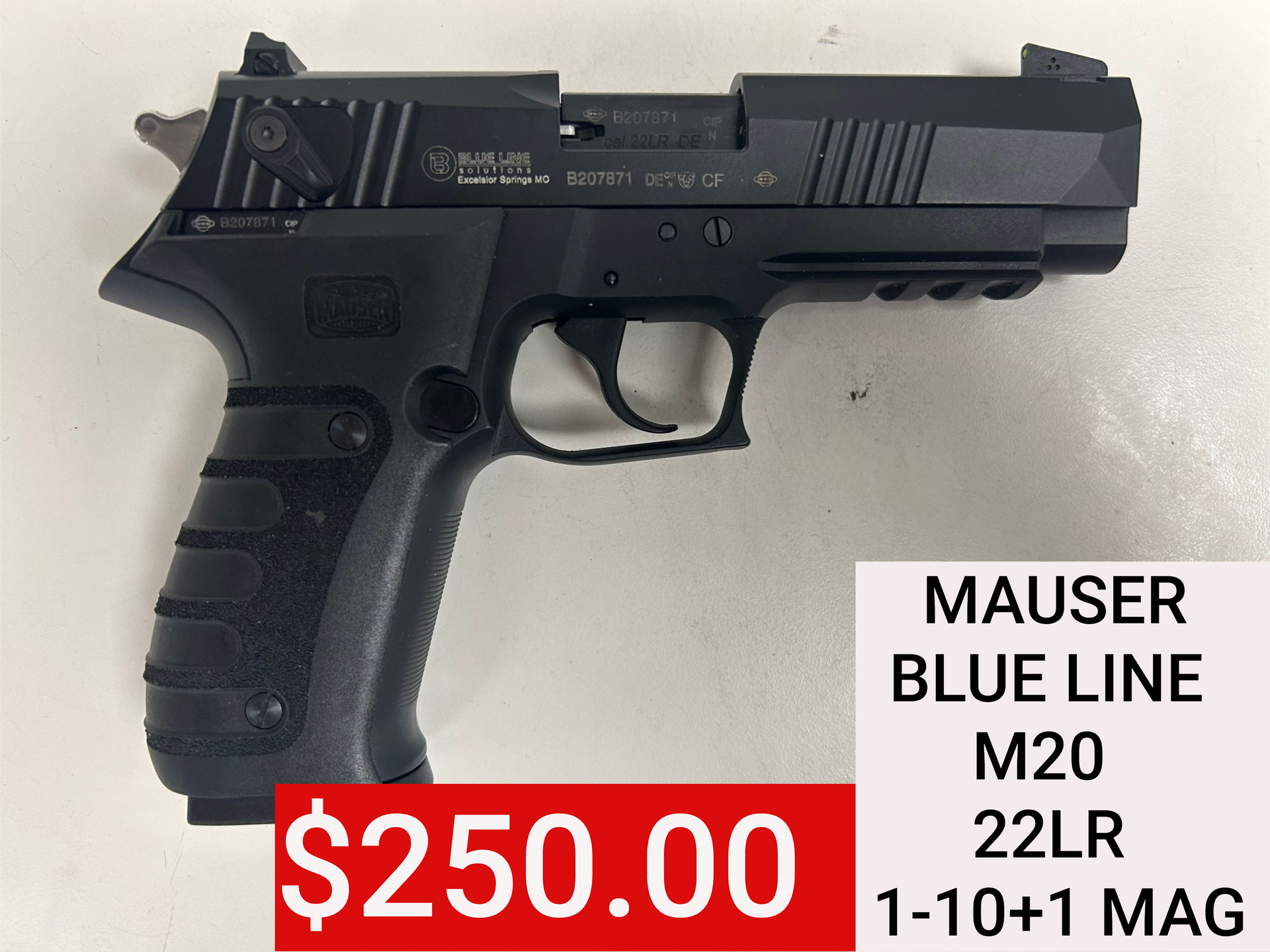 Black handgun on a white surface with a red