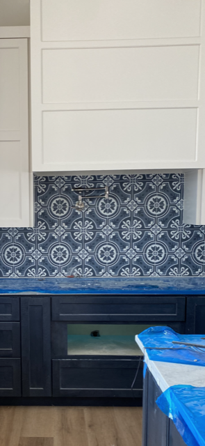 A kitchen with blue cabinets and white cabinets and a blue counter top.