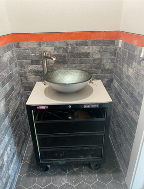 A bathroom with a sink on top of a black cabinet.