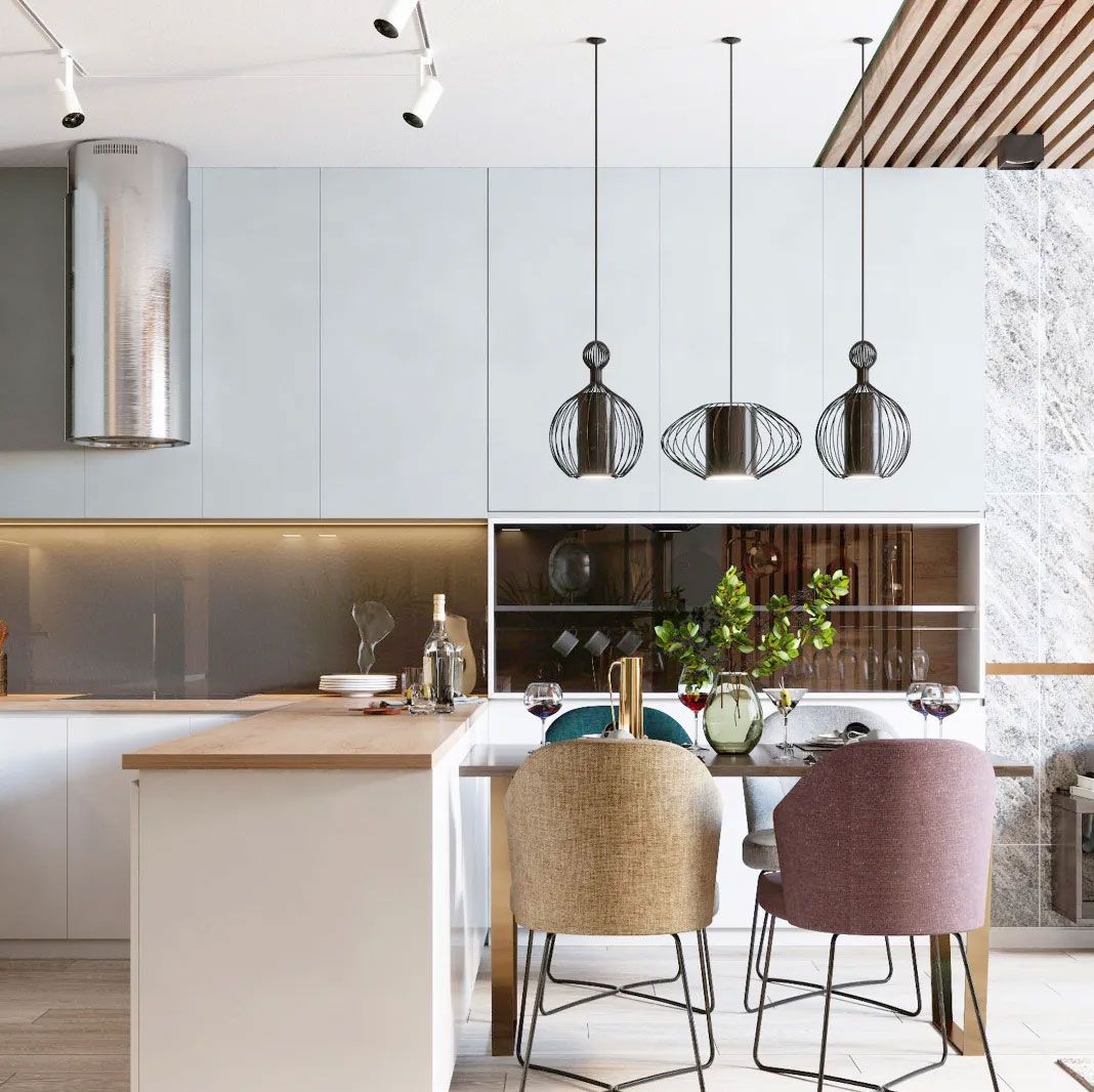 A modern kitchen with a light blue wall, wooden countertop, and three pendant lights above a dining table with unique chairs.
