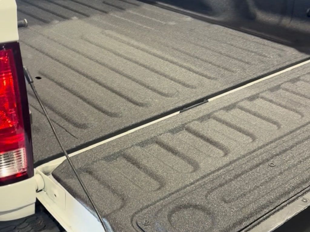 Truck bed with textured black liner and red taillight