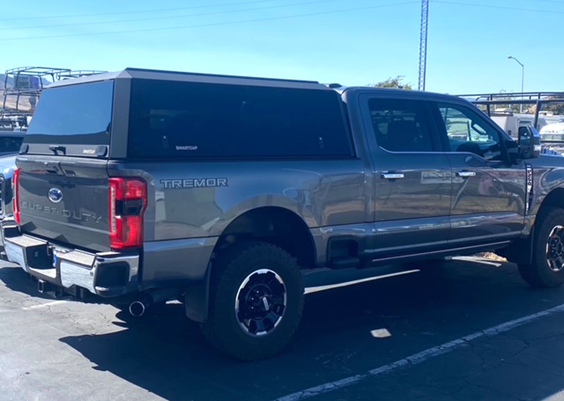 Gray pickup truck parked outdoors in a lot under a clear blue sky