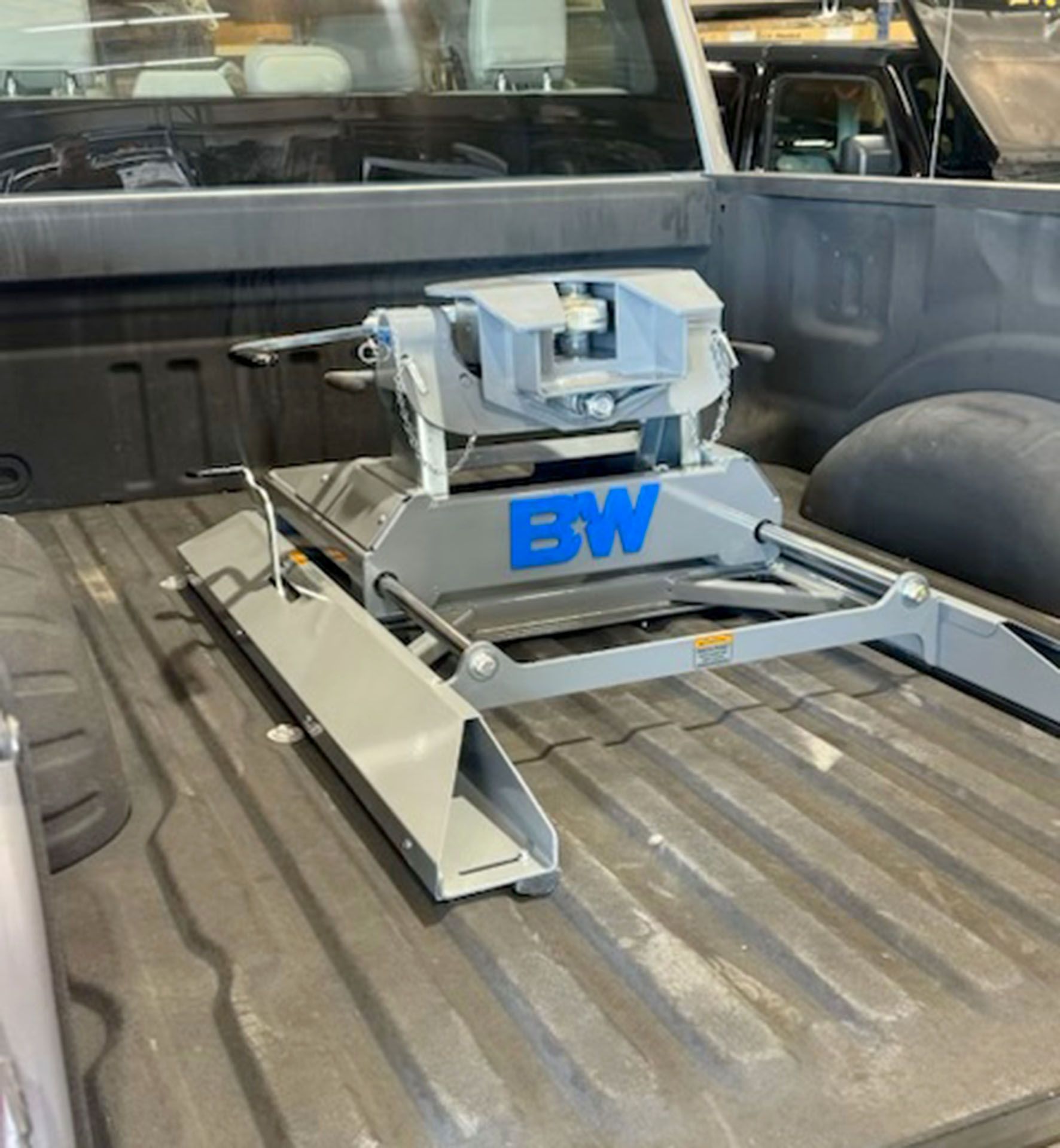 Blue truck bed-mounted equipment with metal frame and rails in the back of a pickup truck