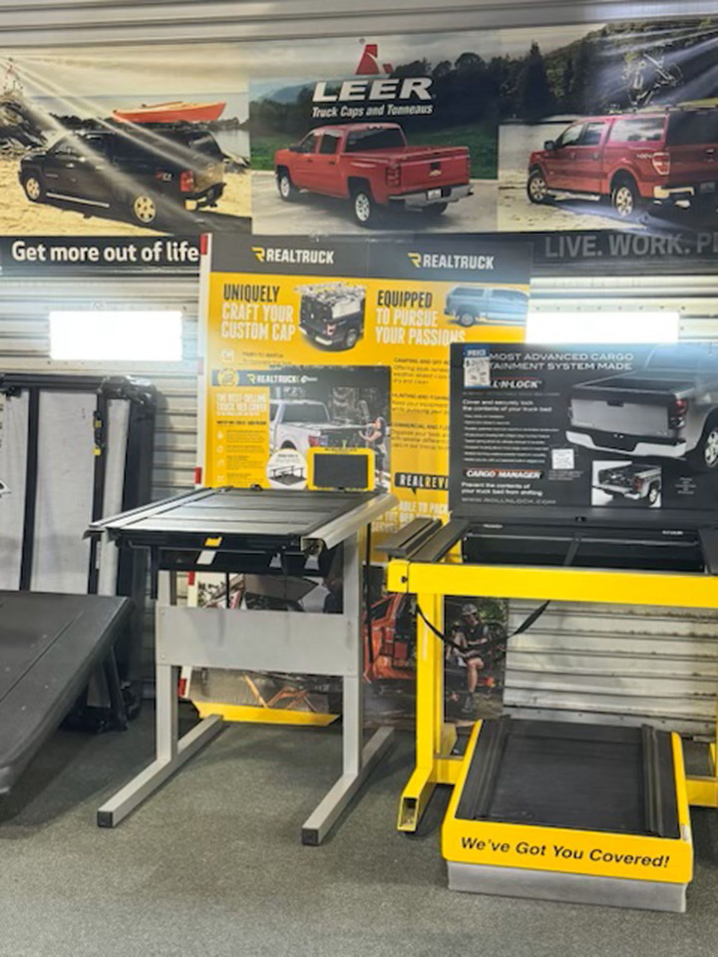 A shop with yellow workbenches and a large wall display of truck images and product ads
