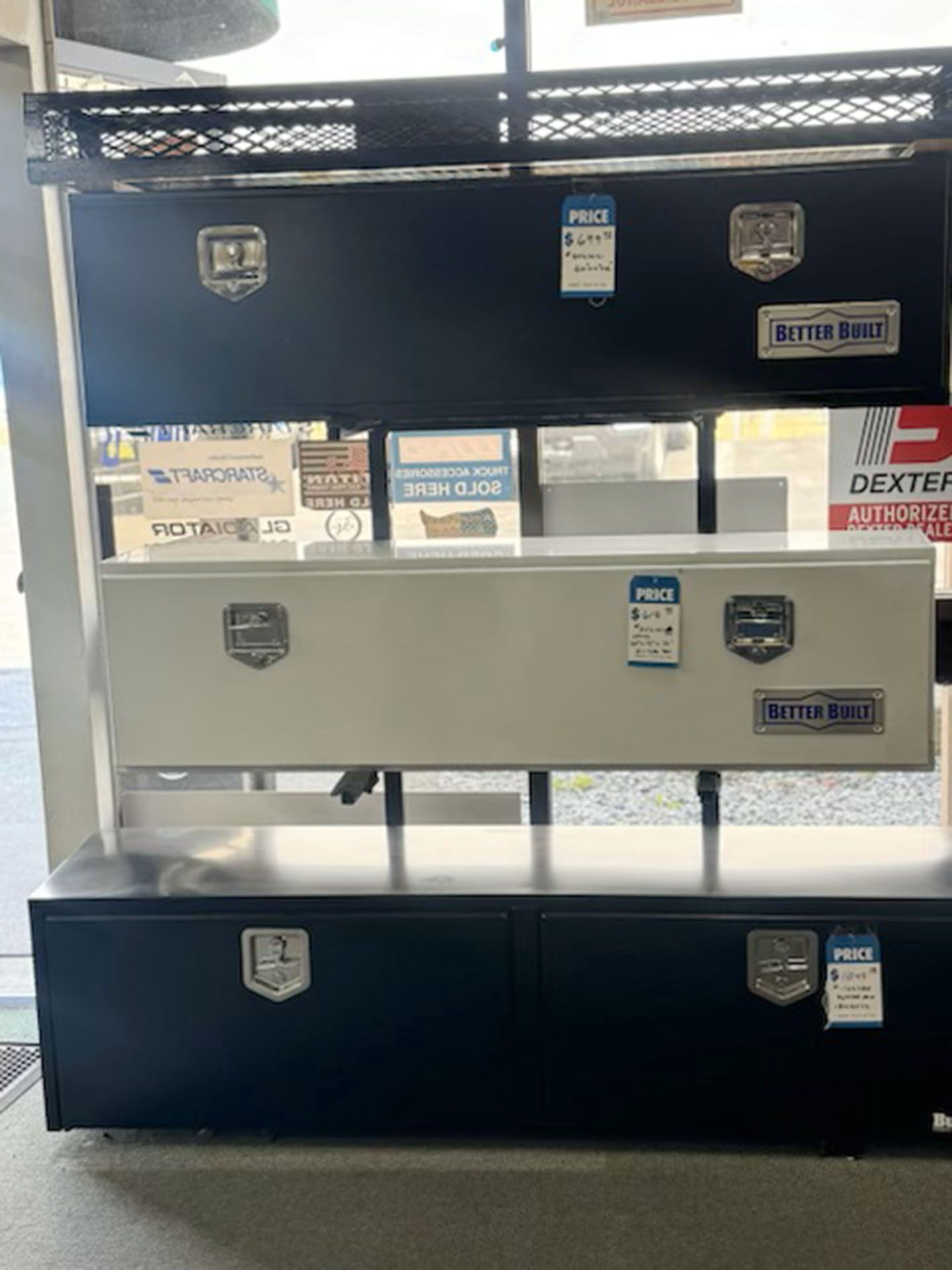Stacked metal toolboxes in black and gray on a display rack
