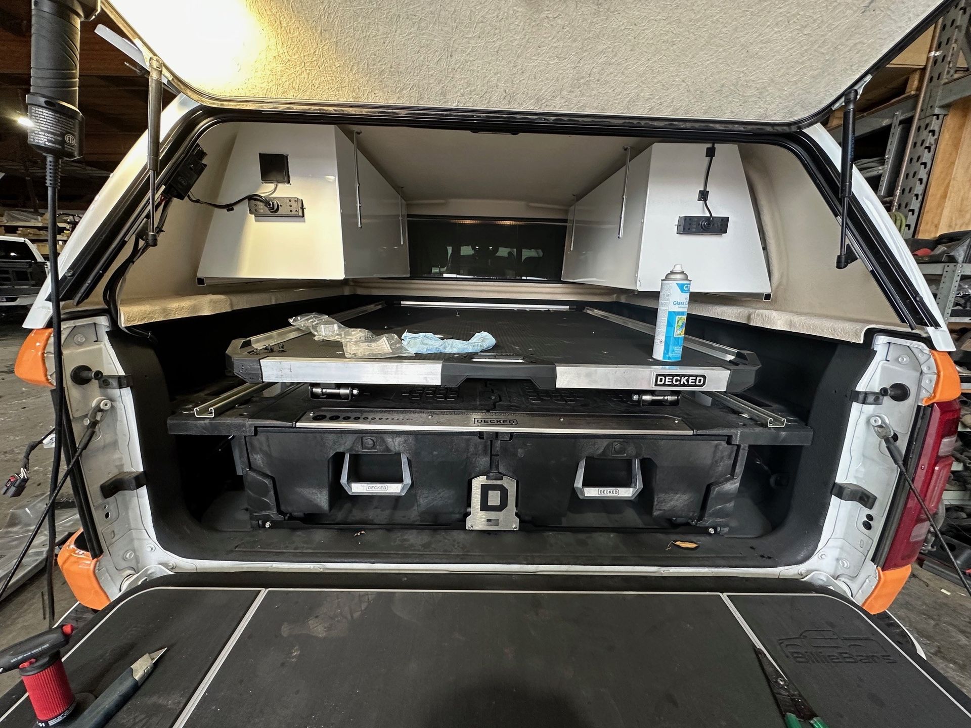 The back of a truck with the trunk open and a toolbox in the back.