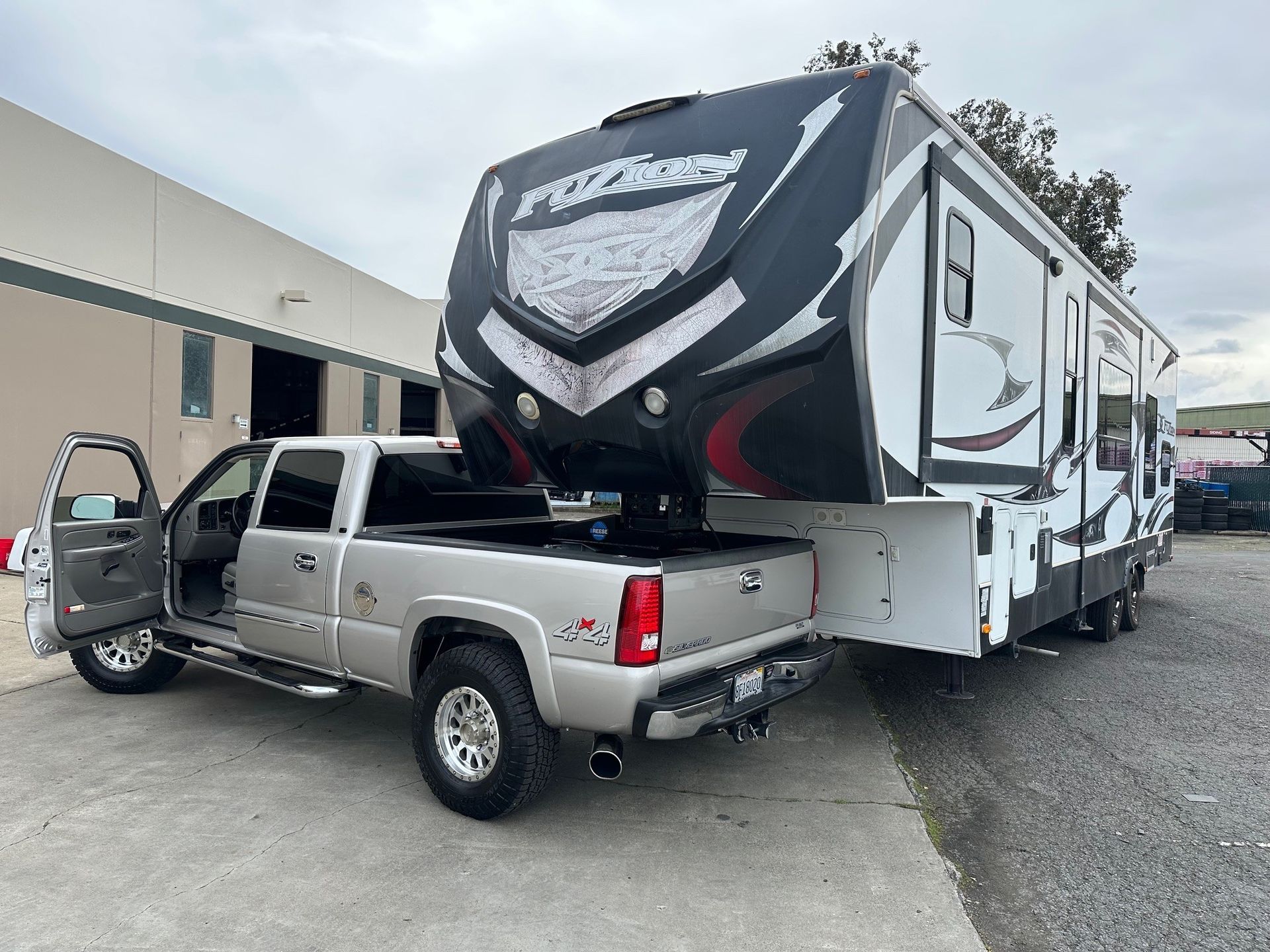 A truck is towing a large trailer in a parking lot.