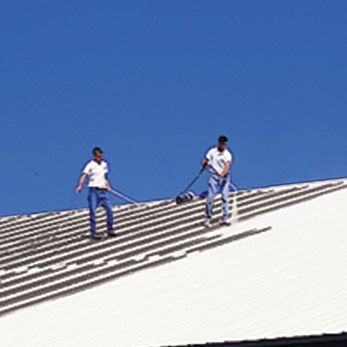 two men are standing on the roof of a building