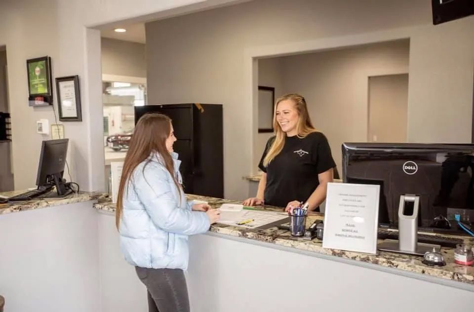 A woman is standing at a counter talking to another woman.