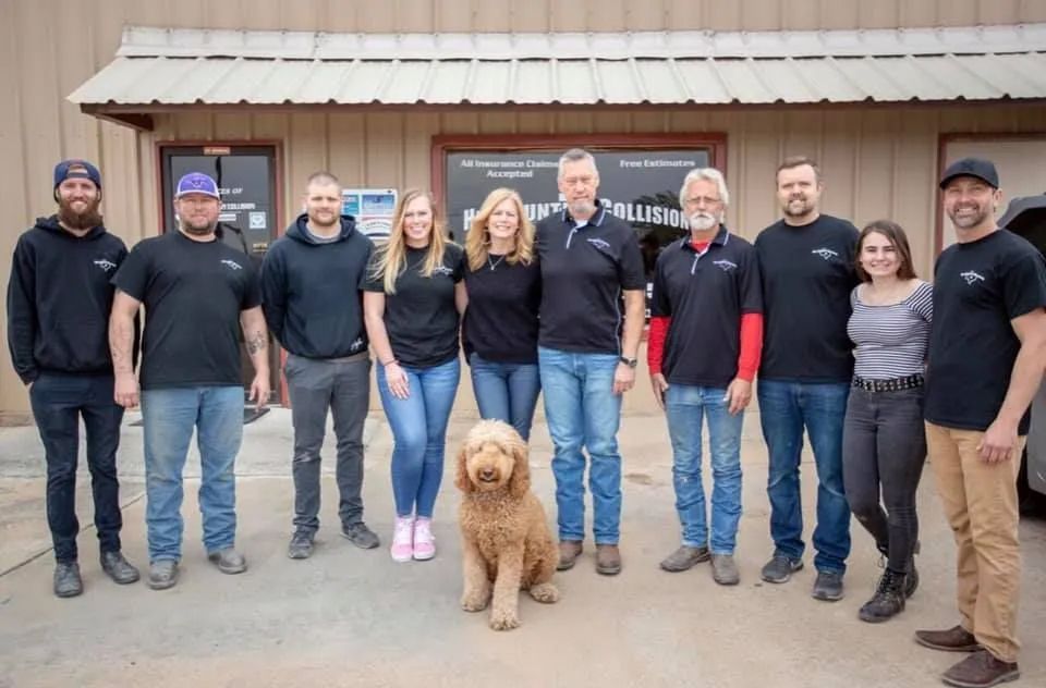 A group of people and a dog are posing for a picture in front of a building.