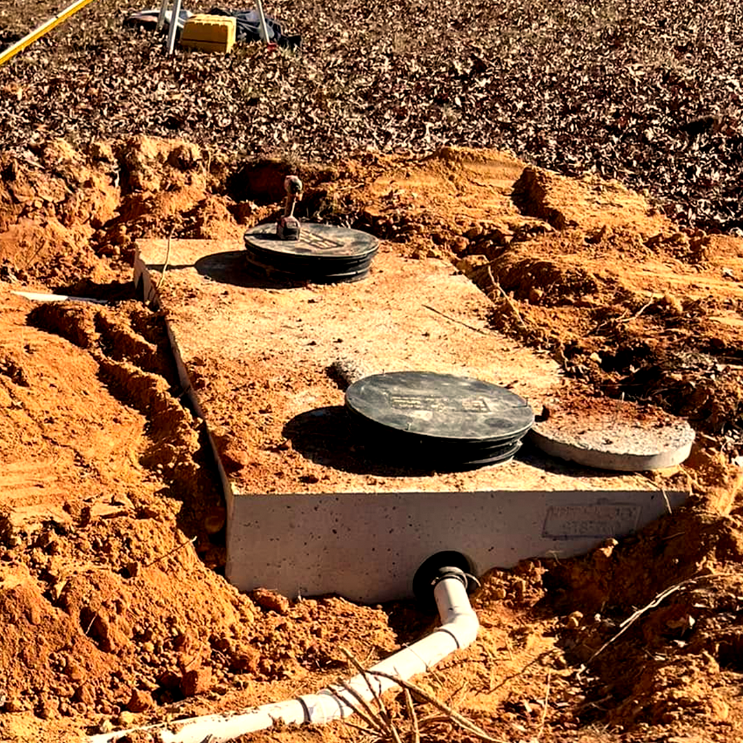 A septic tank is sitting in the middle of a dirt field.