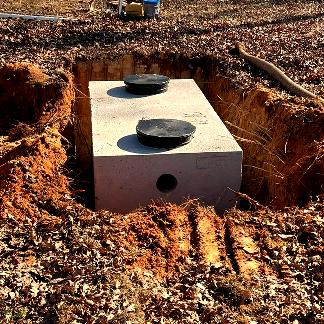 A septic tank is sitting in the middle of a dirt field.