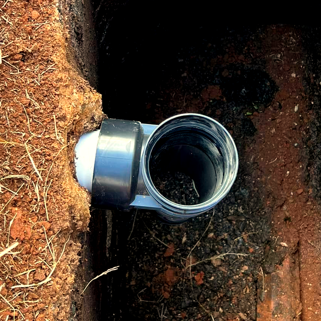 A pipe is being installed in a hole in the ground.