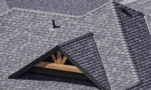 An aerial view of a roof with a triangle shaped window.