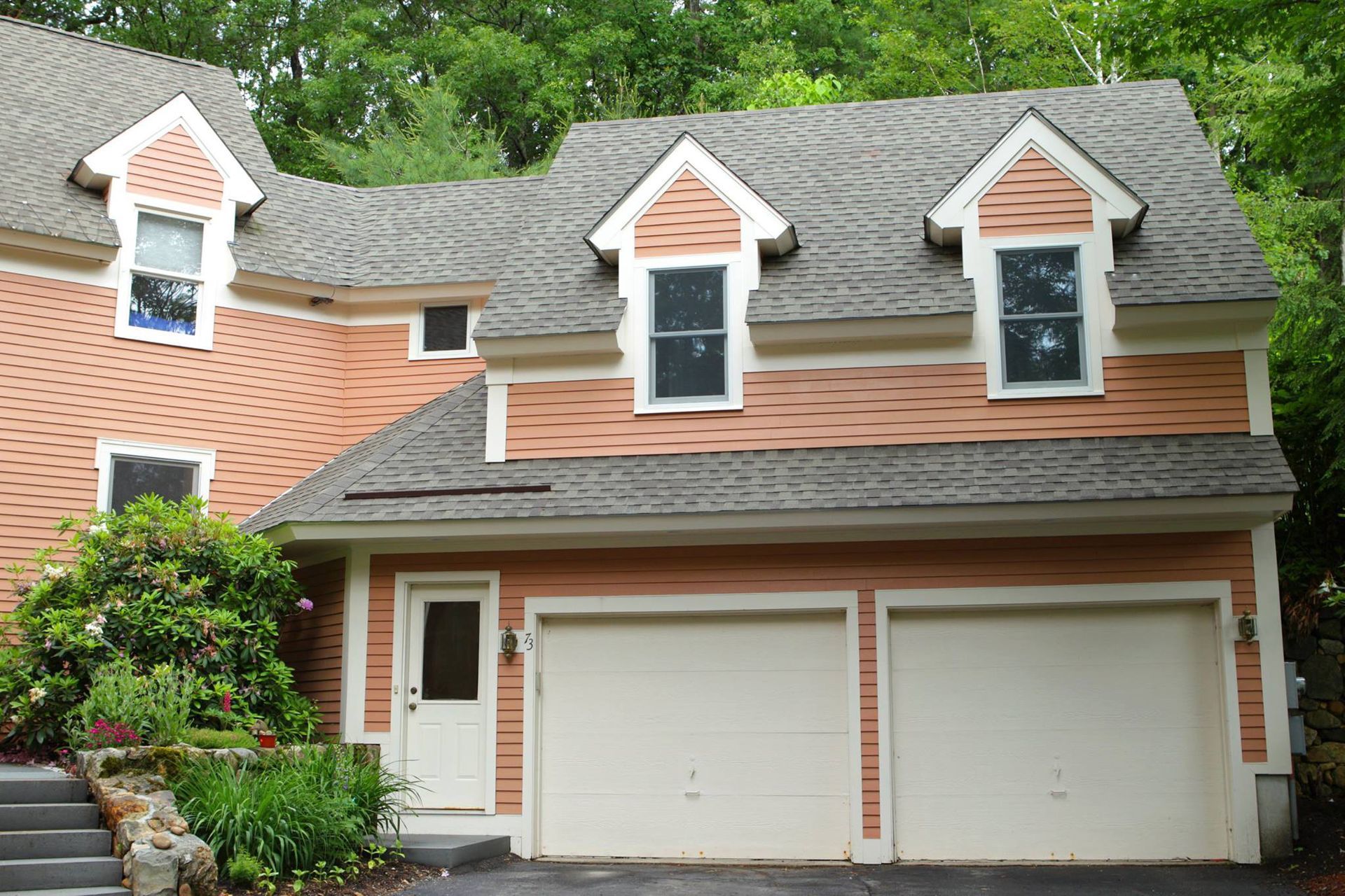 A red brick house with a white garage door