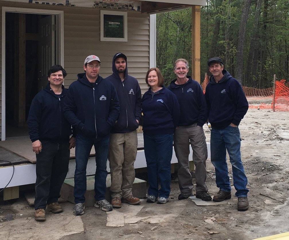 A group of people posing for a picture in front of a house