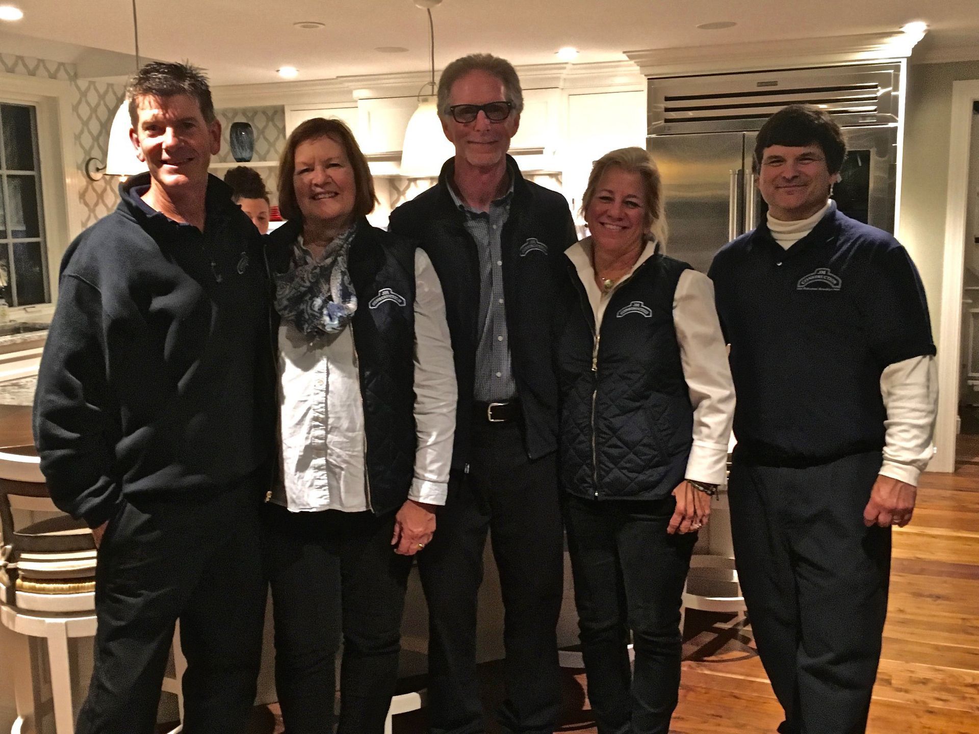 A group of people posing for a picture in a kitchen