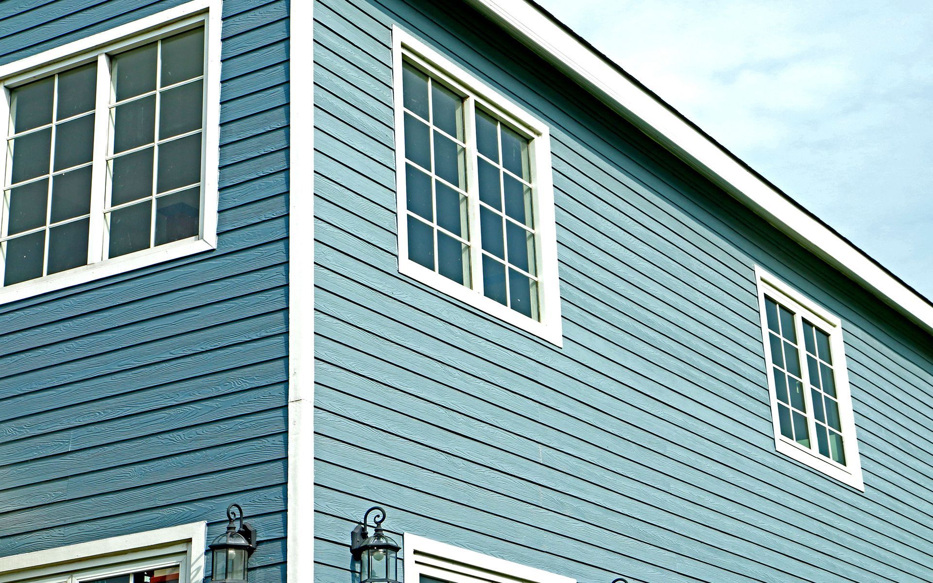 A blue house with white trim and a lot of windows