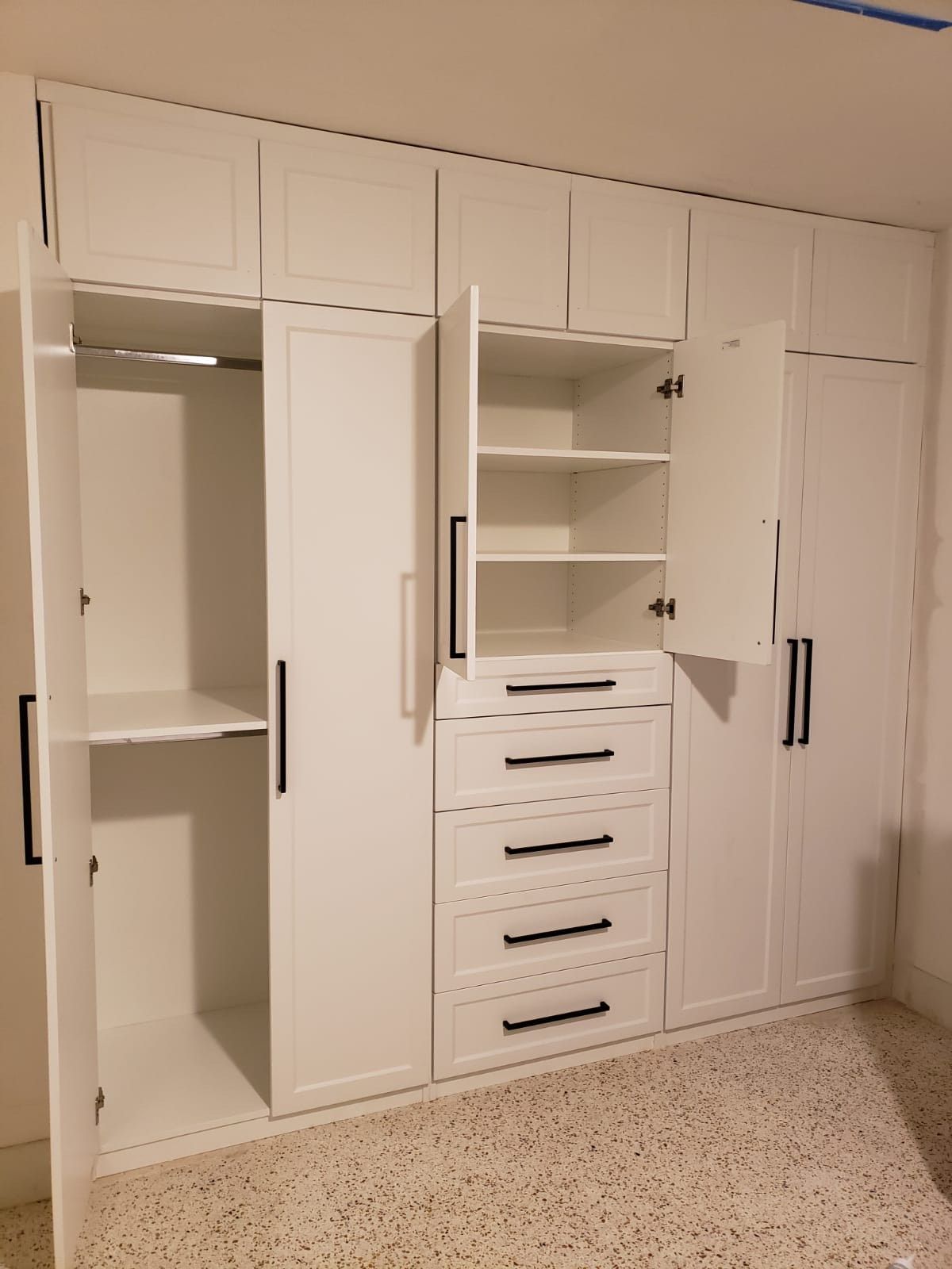 A large white closet with the doors open and drawers