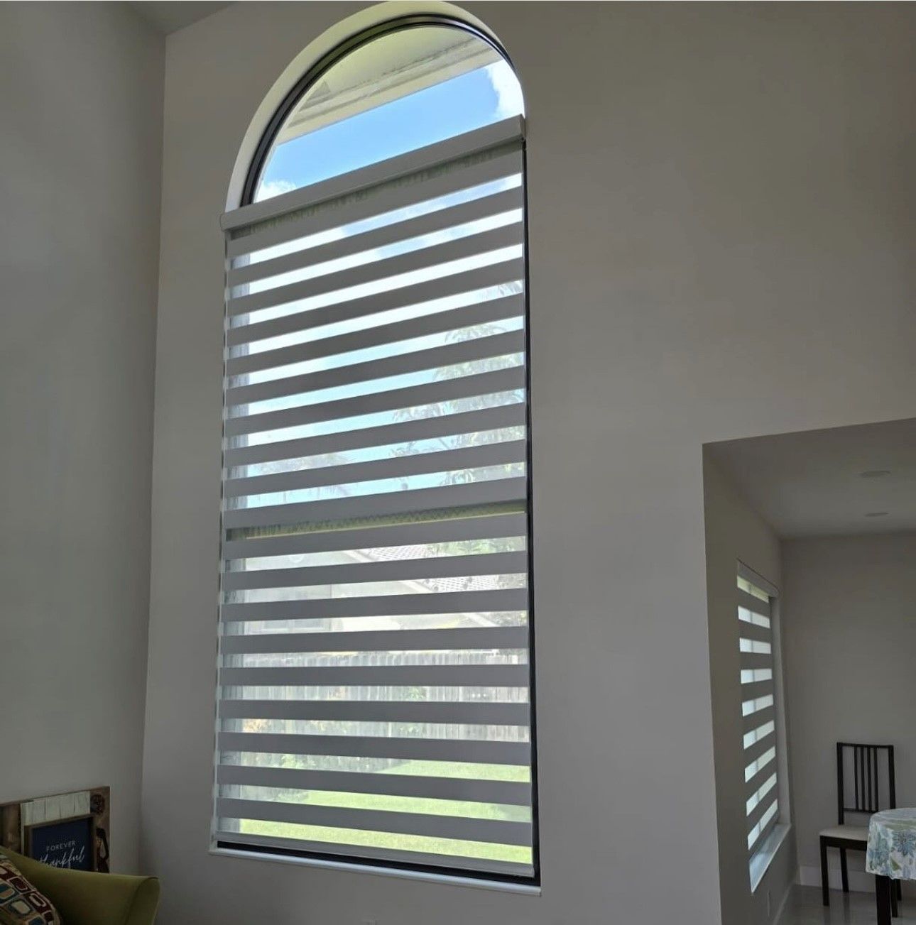 A large window with striped blinds in the living room