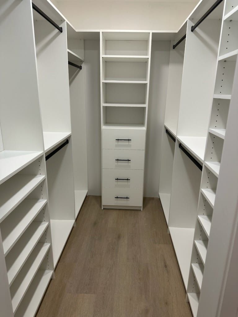 a walk-in closet with lots of shelves and drawers
