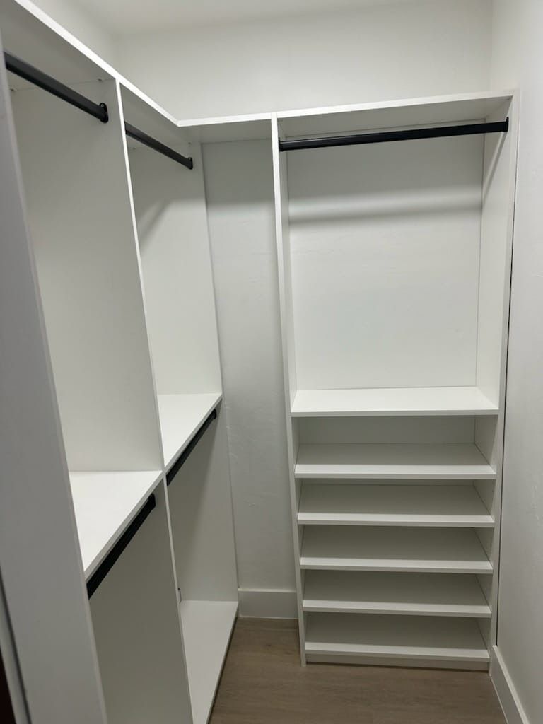 a walk-in closet with lots of shelves and space for hanging clothes