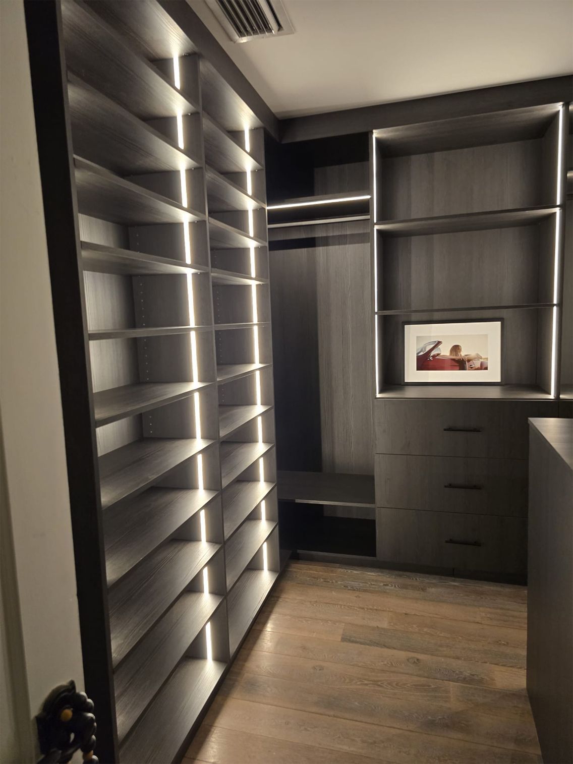 A walk in closet with lots of shelves and drawers