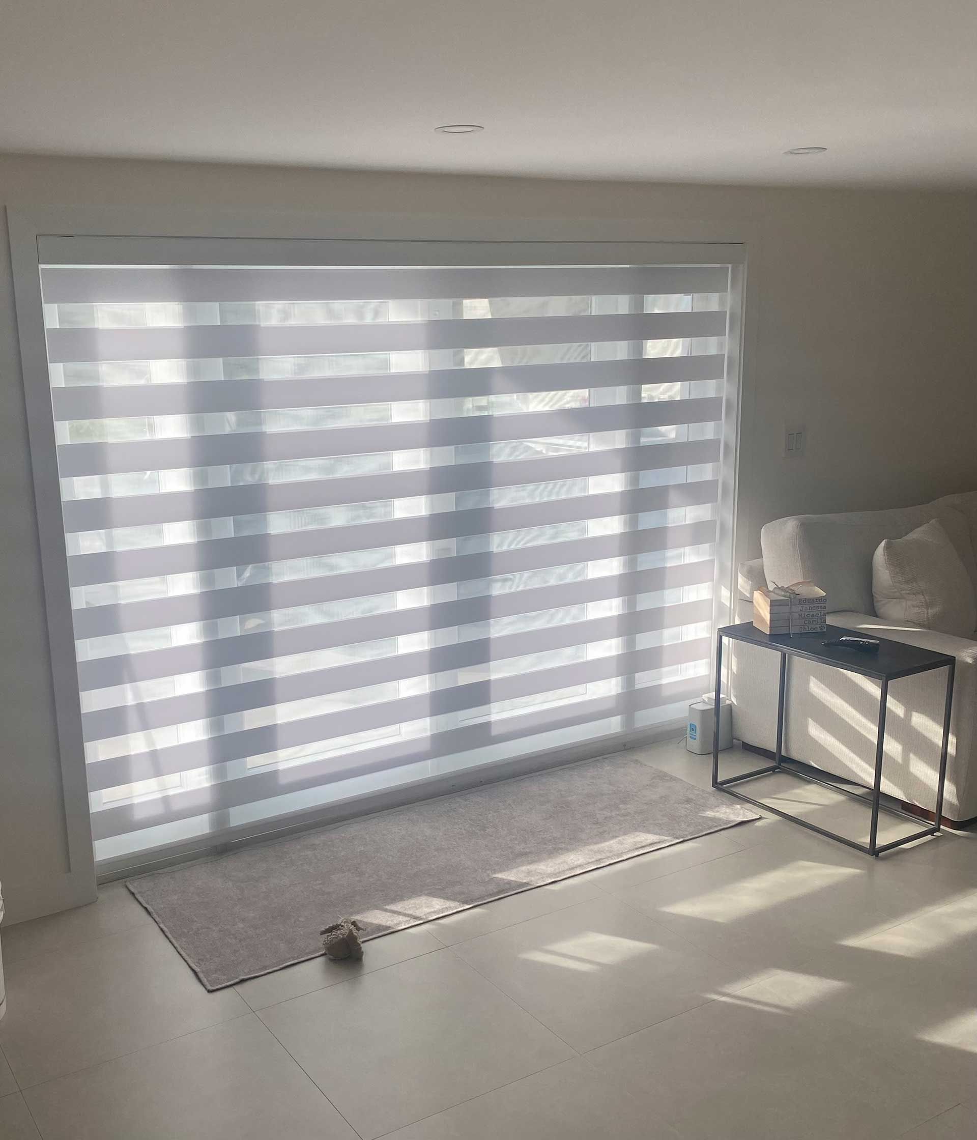a living room with a couch, table, and beautiful window treatment