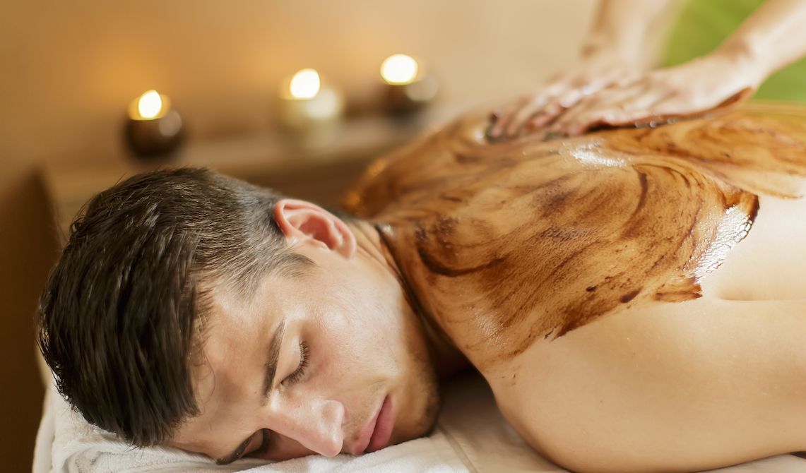 A man is getting a chocolate massage at a spa.