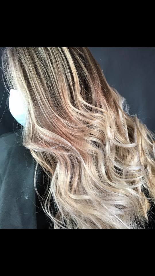 A close up of a woman 's hair with braids and highlights.