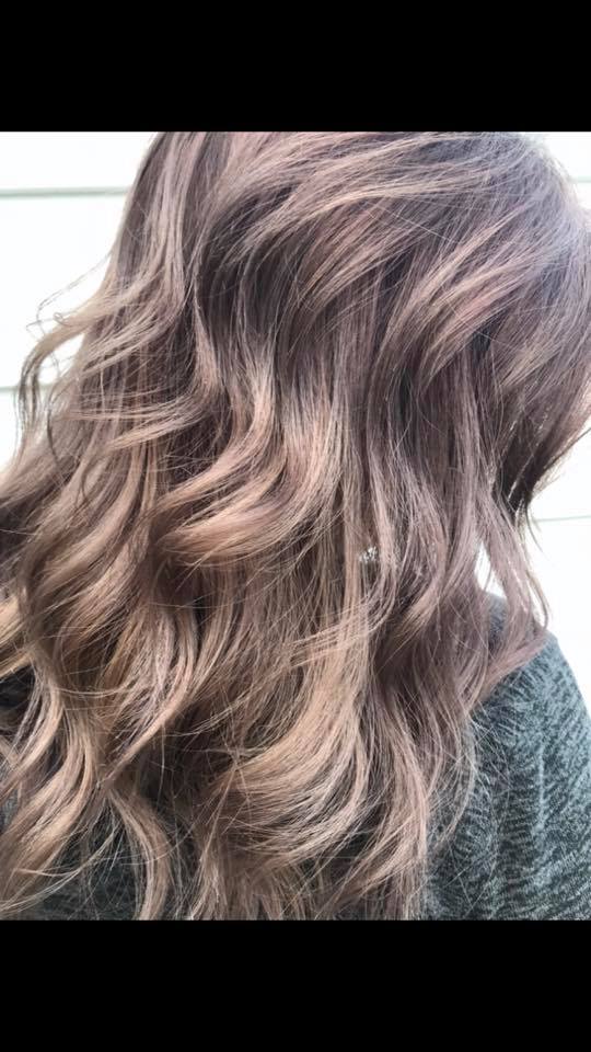 A close up of a woman 's long wavy brown hair.
