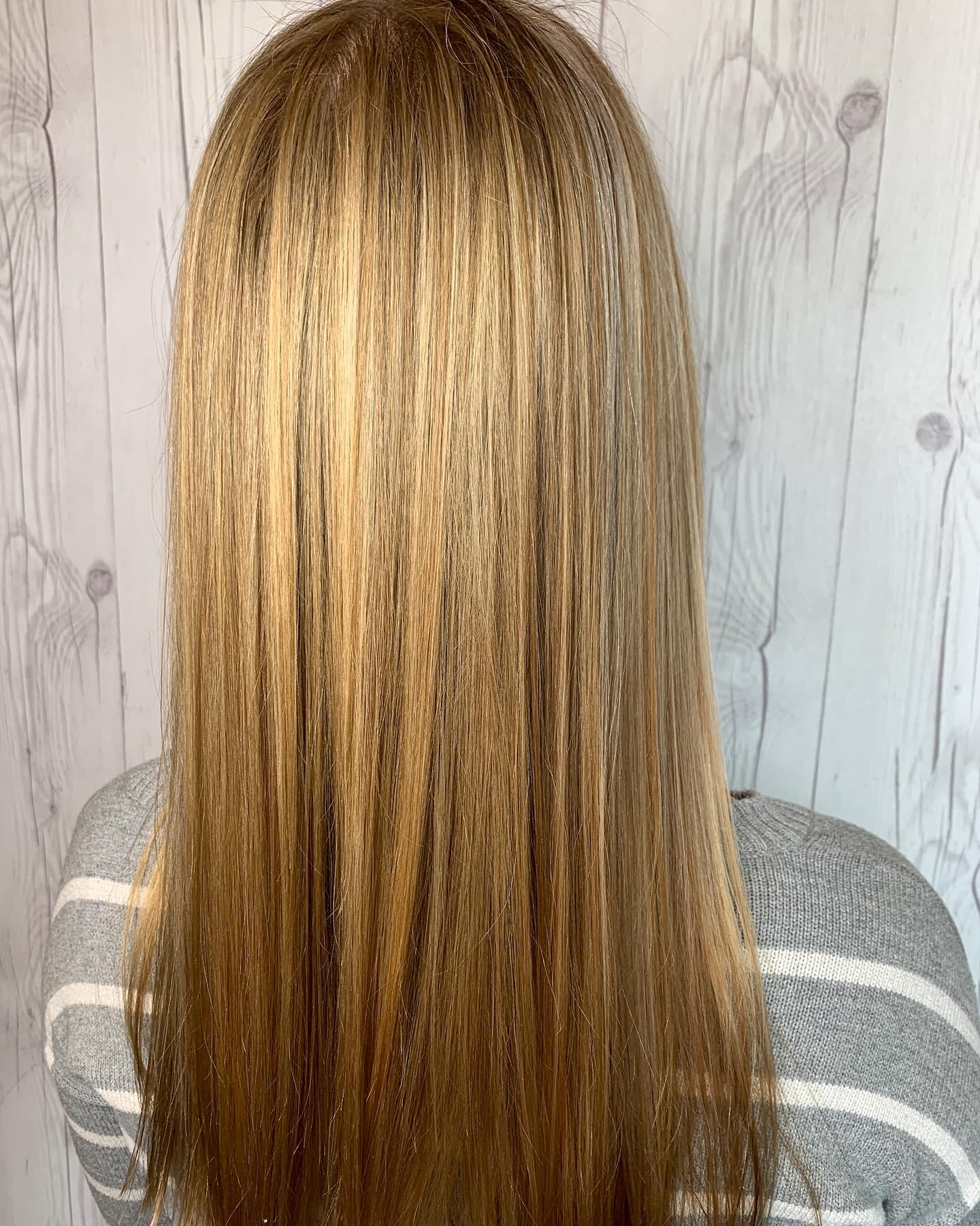 The back of a woman 's head with long blonde hair.