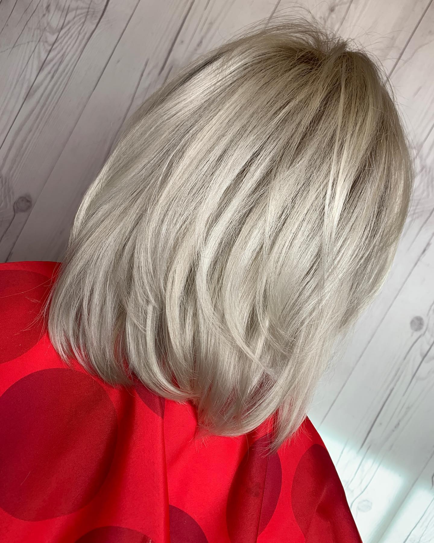 A woman with blonde hair is wearing a red polka dot dress.