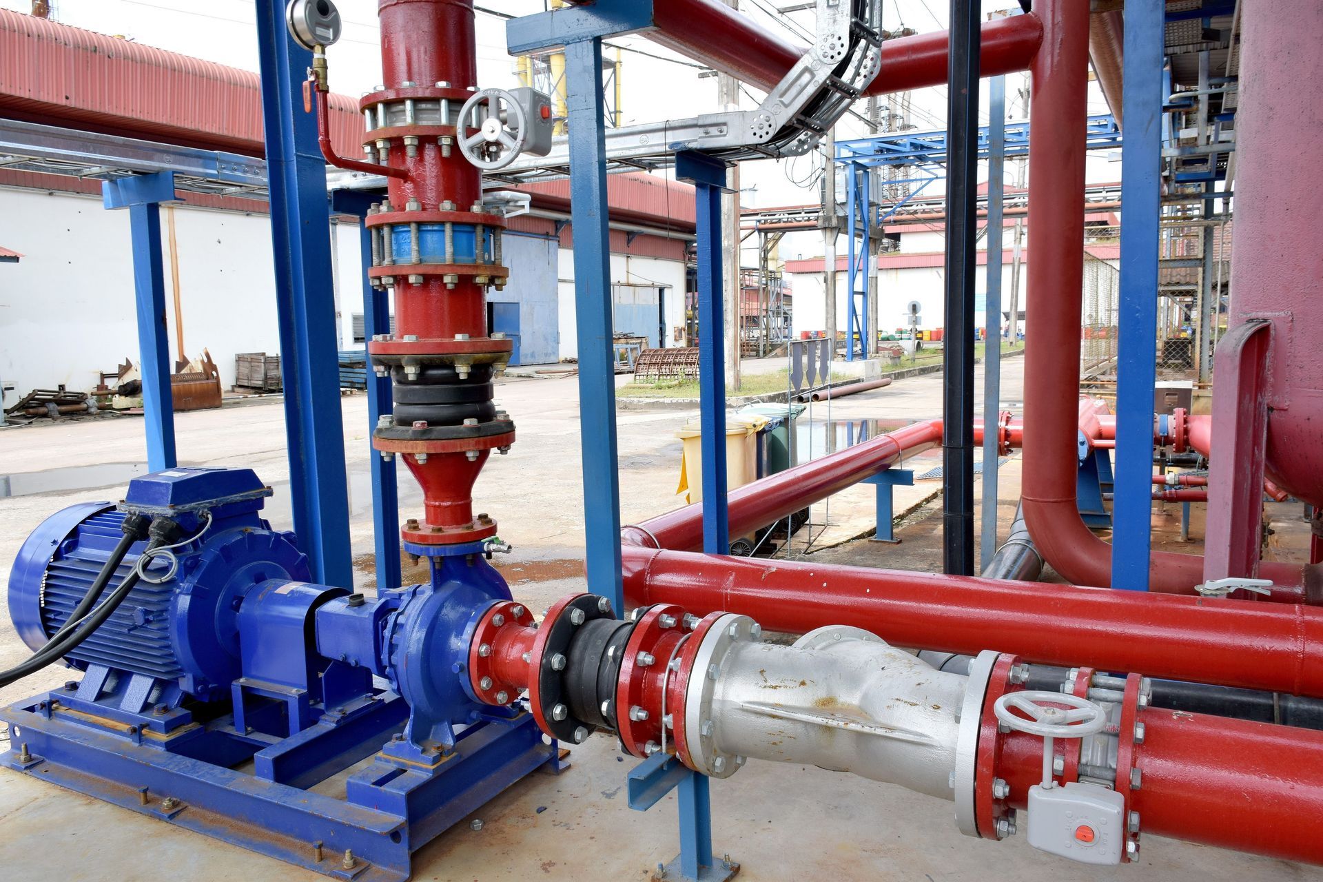 Blue pump and red pipes in industrial setting.