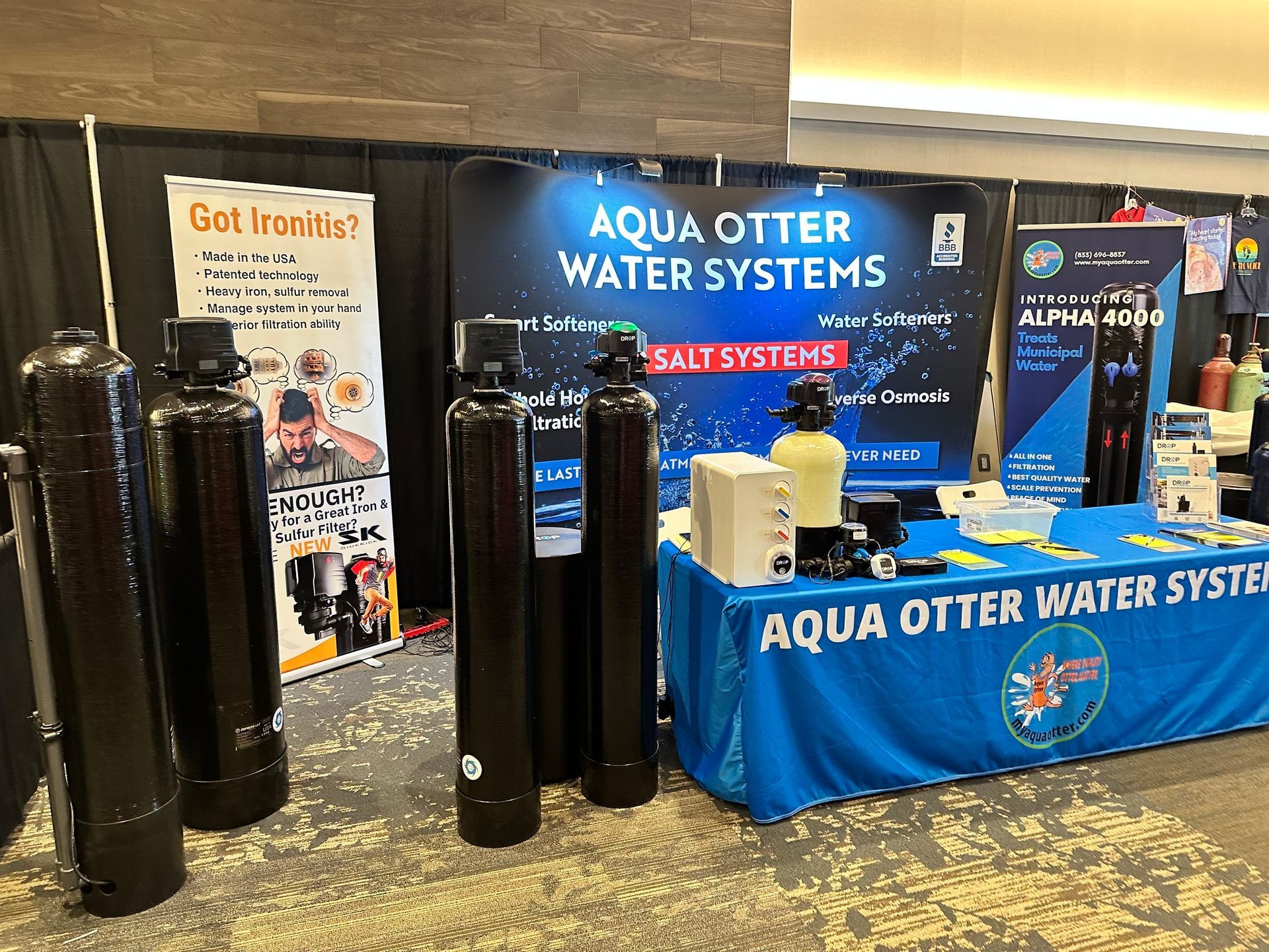 An exhibit booth for Aqua Otter Water Systems, displaying water filtration equipment, banners, and brochures.
