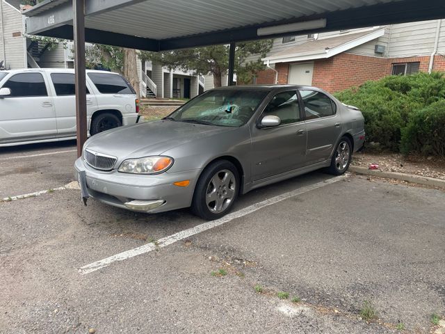 Silver coupe parked under a carport next to a white SUV in an apartment lot.
