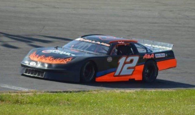 A race car with the number 12 on it is driving down a track.