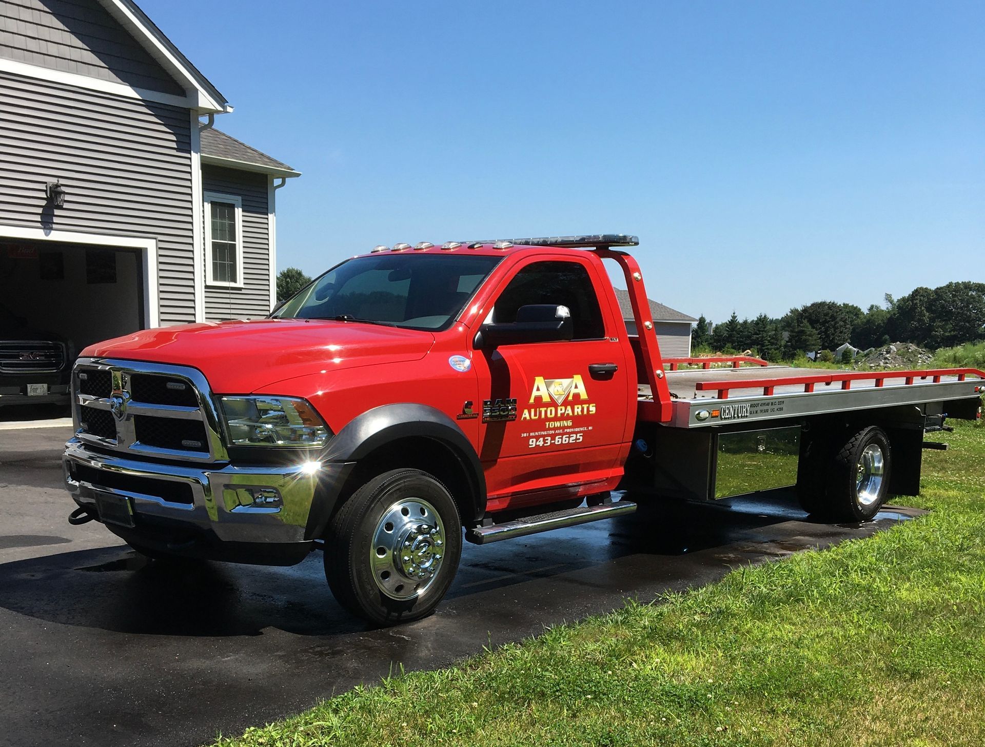 A red tow truck is parked in front of a house