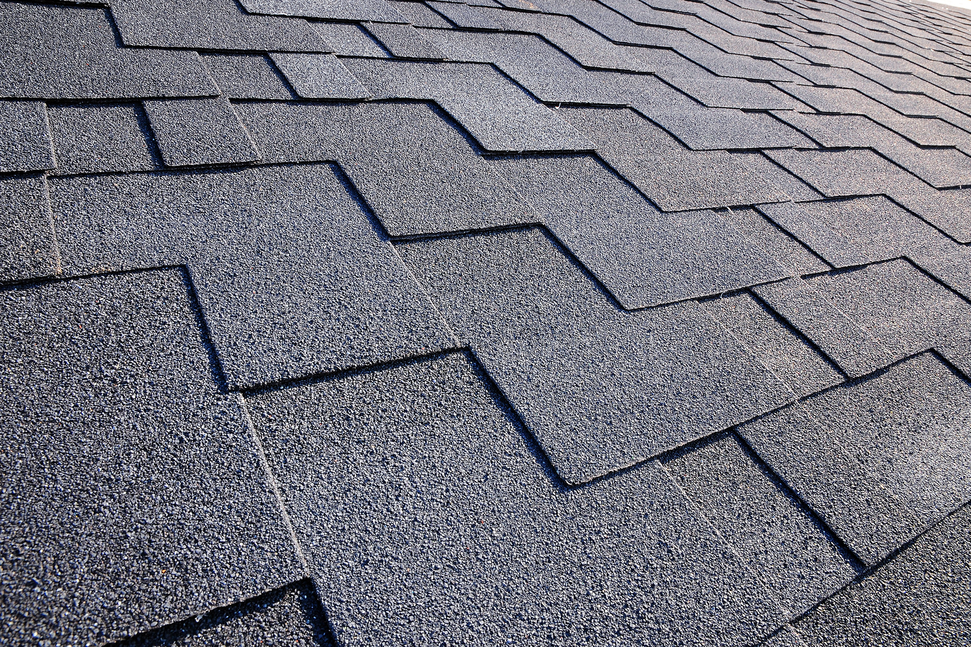 Close-up of a dark gray asphalt shingle roof, angled view.