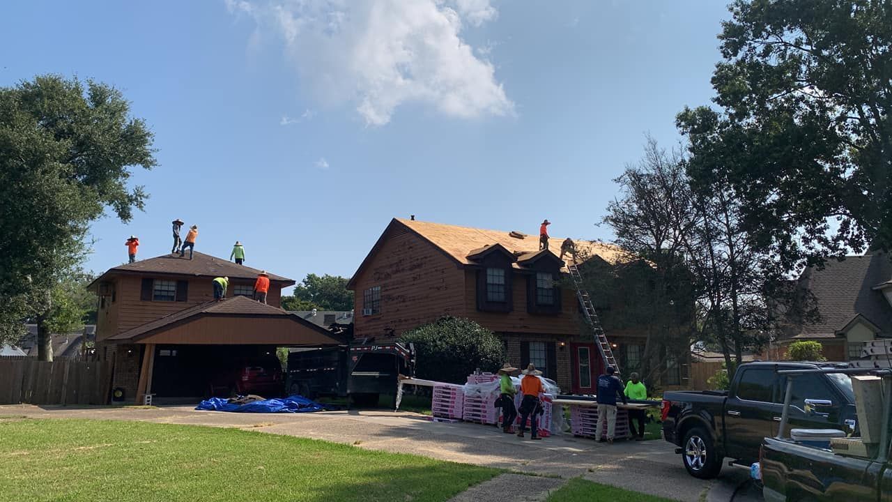 A group of people are working on the roof of a house.