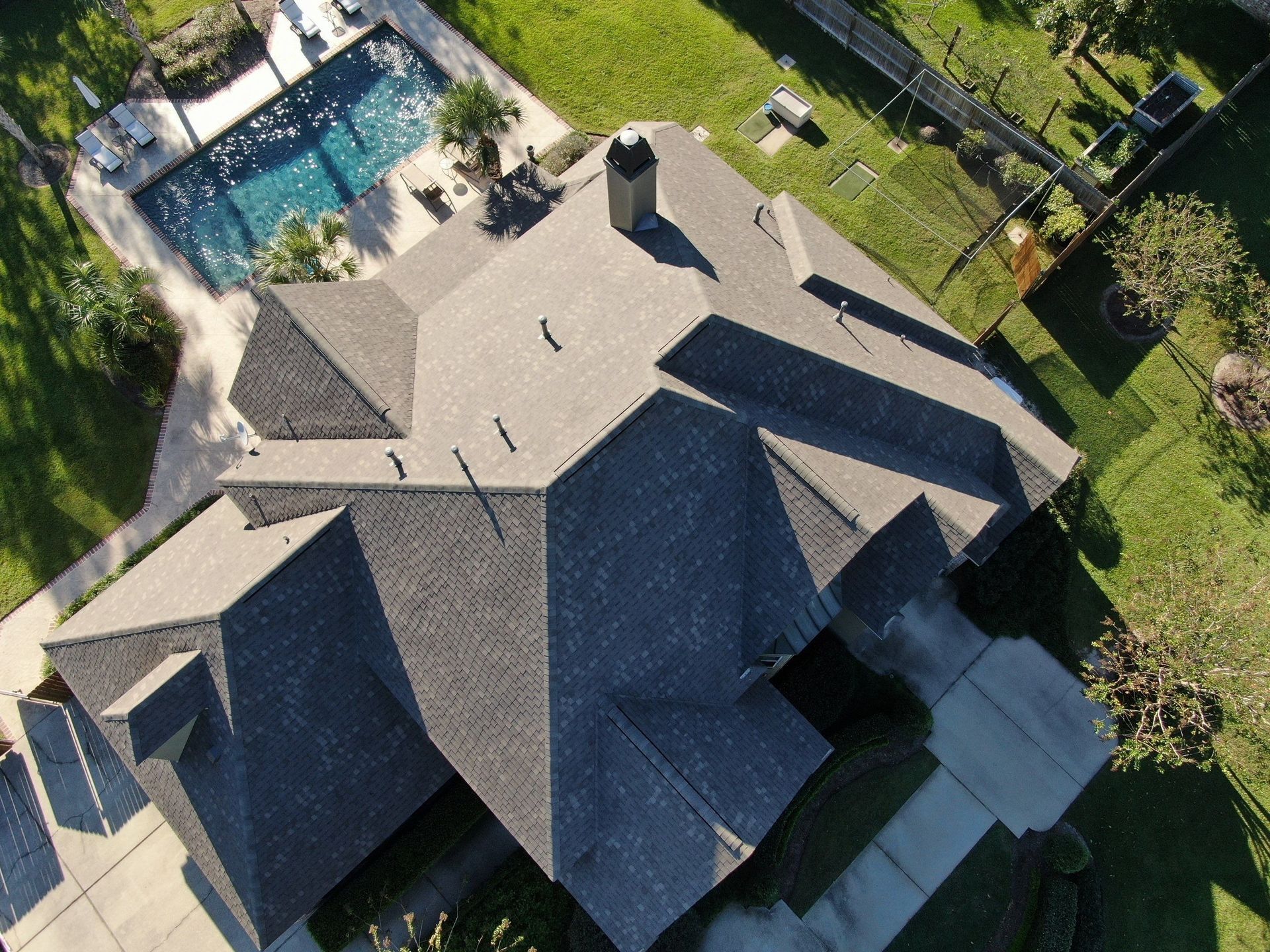 An aerial view of a house with a pool in the backyard.