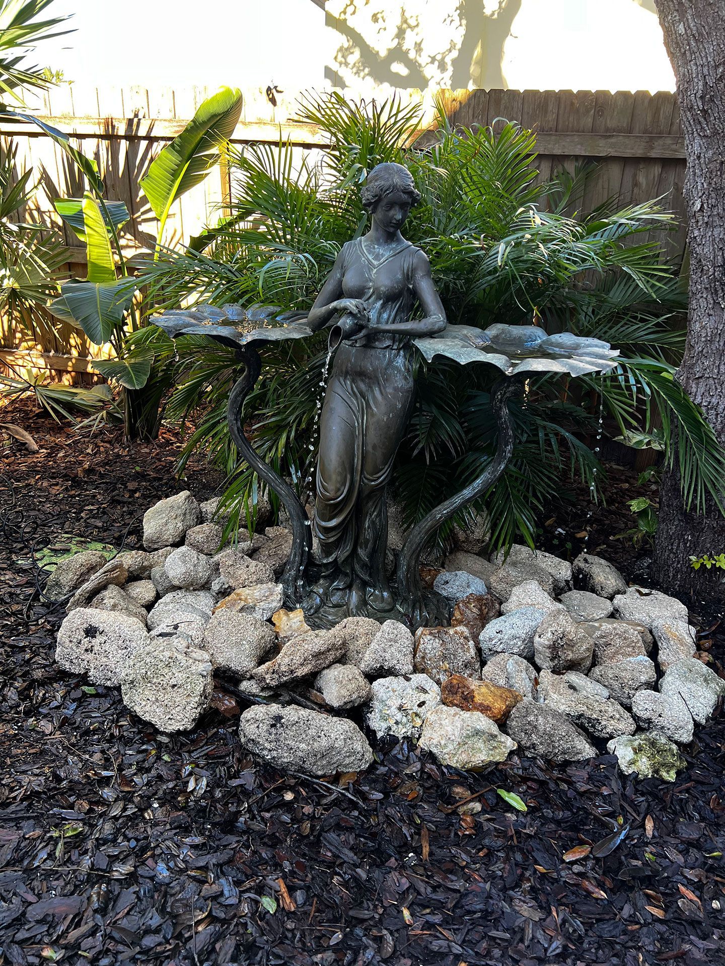 statue with rocks and plants in the garden