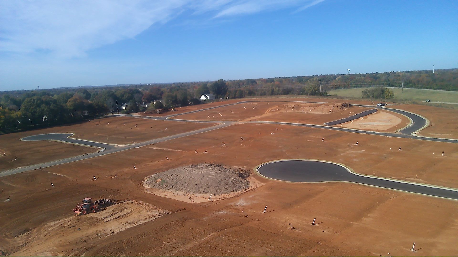 Construction site with dirt, roads, and a blue sky.