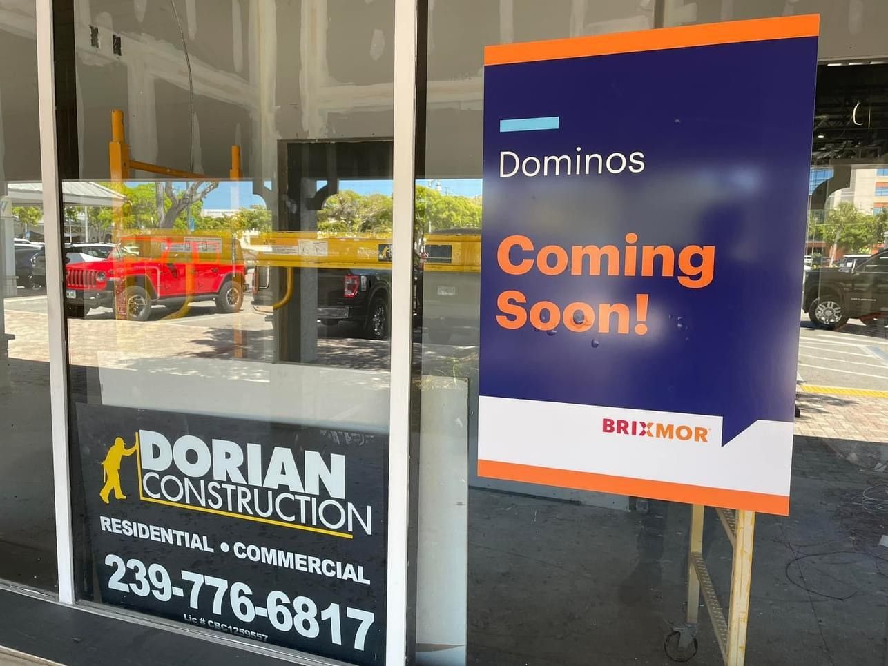 A building under construction with a sign that says domino 's coming soon.