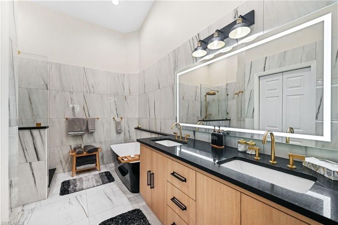 A bathroom with two sinks and a large mirror.