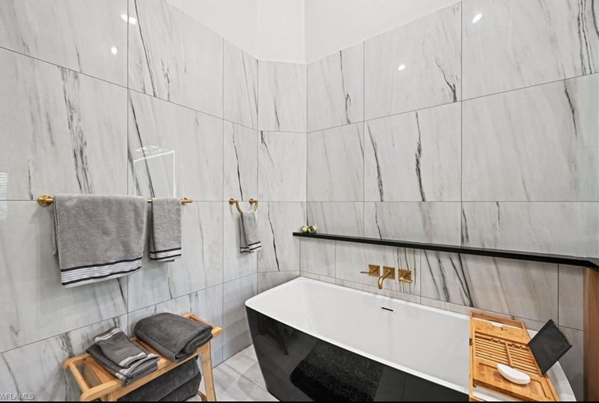 A bathroom with a bathtub , towels , and a shower.