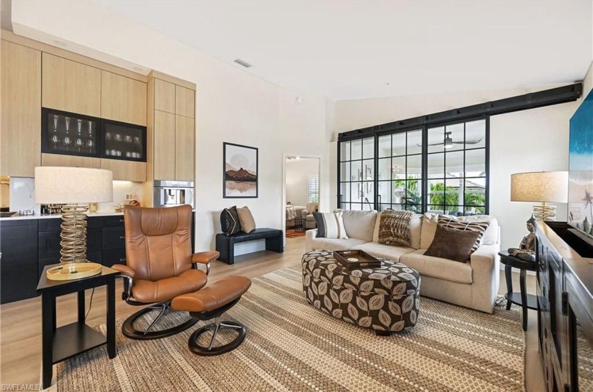 A living room with a couch , chair and ottoman.